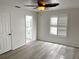 This main bedroom has wood flooring, a ceiling fan and a bathroom with gold hardware visible through doorway at 9319 Se 173Rd Hyacinth St, The Villages, FL 32162