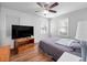 Inviting bedroom with a queen-size bed, ceiling fan, hardwood floors, and natural light from two windows at 1418 Florida Ave, St Cloud, FL 34769