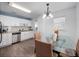 Bright dining area with glass table, hardwood floors, and modern lighting, adjacent to the well-equipped kitchen at 1418 Florida Ave, St Cloud, FL 34769