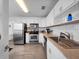 Well-lit kitchen with stainless steel appliances, white cabinetry, hardwood floors, and a modern sink at 1418 Florida Ave, St Cloud, FL 34769