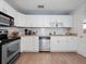 Well-lit kitchen featuring white cabinets, stainless steel appliances, and modern backsplash at 1418 Florida Ave, St Cloud, FL 34769