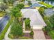 Single-story home with large trees and tropical landscaping on a corner lot in a quiet residential neighborhood at 100 Ventana Dr, Kissimmee, FL 34759