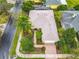 Charming home featuring lush garden, mature trees, and a patterned brick driveway at 100 Ventana Dr, Kissimmee, FL 34759