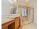 Bright bathroom featuring a double vanity, spacious shower with glass door and neutral tile at 100 Ventana Dr, Kissimmee, FL 34759