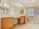 Bright bathroom featuring a double vanity, spacious shower with glass door and neutral tile at 100 Ventana Dr, Kissimmee, FL 34759