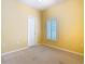 Bright bedroom featuring neutral carpet, window with shutters, and a white paneled door at 100 Ventana Dr, Kissimmee, FL 34759