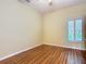 An empty bedroom is illuminated by a window with shutter-style blinds and features wood flooring at 100 Ventana Dr, Kissimmee, FL 34759