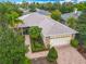 Beautiful single-story home showcasing a well-manicured lawn, tropical landscaping, and brick paved driveway at 100 Ventana Dr, Kissimmee, FL 34759
