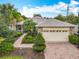 Charming single-story home featuring manicured landscaping, brick driveway, and a welcoming two-car garage at 100 Ventana Dr, Kissimmee, FL 34759