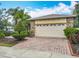 Charming home featuring a brick paver driveway, two car garage, and professionally landscaped front yard at 100 Ventana Dr, Kissimmee, FL 34759