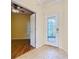Inviting foyer with tile flooring and a glass paneled front door, leading to a wood-floored room at 100 Ventana Dr, Kissimmee, FL 34759