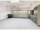 Spacious two car garage with storage cabinets, clean epoxy flooring, and an automatic door opener at 100 Ventana Dr, Kissimmee, FL 34759