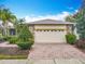 Attached two-car garage featuring beautiful brick pavers and a well-manicured front yard at 100 Ventana Dr, Kissimmee, FL 34759