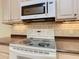 Bright kitchen features a smooth cooktop range and tile backsplash at 100 Ventana Dr, Kissimmee, FL 34759