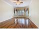 Spacious living room featuring hardwood flooring, a ceiling fan, and multiple windows with coverings at 100 Ventana Dr, Kissimmee, FL 34759