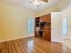 Bright office featuring wood flooring, built-in desk, shelving and a large window with plantation shutters at 100 Ventana Dr, Kissimmee, FL 34759