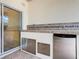 This outdoor kitchen features a stainless steel mini fridge, grill, sink, and ceramic tile backsplash at 100 Ventana Dr, Kissimmee, FL 34759
