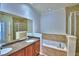 Well-lit bathroom showcasing double sink vanity, soaking tub, and tiled shower at 1111 Oscar Sq, Celebration, FL 34747