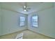 Bright bedroom with neutral carpet and walls, ceiling fan, and two windows at 1111 Oscar Sq, Celebration, FL 34747