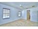 Carpeted bedroom featuring two windows and an open door to the hall at 1111 Oscar Sq, Celebration, FL 34747