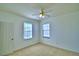 Bright bedroom with neutral carpet, a ceiling fan, and two windows with blinds at 1111 Oscar Sq, Celebration, FL 34747