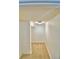 Narrow hallway with carpet flooring and white walls, leading to additional spaces at 1111 Oscar Sq, Celebration, FL 34747