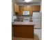 Cozy kitchen features wooden cabinets, white appliances, and a breakfast bar at 1111 Oscar Sq, Celebration, FL 34747