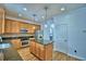 Kitchen features stainless steel appliances, an island with granite counter, and wooden cabinetry at 1111 Oscar Sq, Celebration, FL 34747