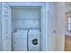 Laundry closet with side-by-side washer and dryer, plus storage shelves at 1111 Oscar Sq, Celebration, FL 34747