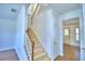 Carpeted stairs featuring wood handrail and banister and an open concept at 1111 Oscar Sq, Celebration, FL 34747
