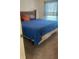 Neutral bedroom with a wooden headboard, blue bedding, a window with blinds and carpeted floors at 1116 Caloosa Ridge Way, Babson Park, FL 33827