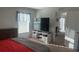 Sunlit bedroom with a modern bed, dresser, and TV console at 1116 Caloosa Ridge Way, Babson Park, FL 33827