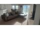 Sun-drenched living room featuring a comfortable sectional sofa and an open layout into the dining area at 1116 Caloosa Ridge Way, Babson Park, FL 33827