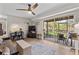 Bright living room featuring wood-look floors, a ceiling fan and sliding glass doors leading to an outdoor area at 11812 Lakeshore Dr, Clermont, FL 34711