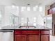 Kitchen island featuring stainless steel sink, black granite counters and pendant lighting at 12761 Westside Village Loop, Windermere, FL 34786