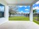Covered back porch featuring view of lake and well maintained lawn at 12791 Westside Village Loop, Windermere, FL 34786