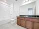 Bright bathroom with a tub/shower combination and a vanity with a dark granite countertop at 12791 Westside Village Loop, Windermere, FL 34786