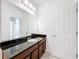 Bathroom vanity featuring a dark granite counter and a large mirror over the sink at 12791 Westside Village Loop, Windermere, FL 34786