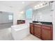 Bright bathroom features a soaking tub, dual vanities with dark granite counters and a separate shower at 12791 Westside Village Loop, Windermere, FL 34786