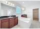 Bathroom featuring a soaking tub, shower, dual sinks with granite counters and tile flooring at 12791 Westside Village Loop, Windermere, FL 34786