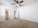 Bedroom with neutral carpet, a ceiling fan and doors leading to the closet and hallway at 12791 Westside Village Loop, Windermere, FL 34786