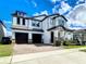 Attractive two story house with a two-car garage, brick driveway, manicured lawn, and covered front porch at 12791 Westside Village Loop, Windermere, FL 34786