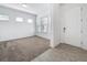 Bright living room with neutral carpeting, three large windows and a white front door at 12791 Westside Village Loop, Windermere, FL 34786
