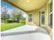 Spacious covered back patio overlooking a lush green lawn and mature trees at 12880 Westside Village Loop, Windermere, FL 34786