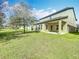 Expansive backyard with green grass and views of the home's covered patio at 12880 Westside Village Loop, Windermere, FL 34786