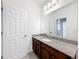 Bathroom with a large mirror, granite countertop and dark wood cabinets at 12880 Westside Village Loop, Windermere, FL 34786