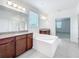 Bright bathroom features double vanity, soaking tub, large mirrors, and updated fixtures at 12880 Westside Village Loop, Windermere, FL 34786