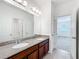 Bathroom featuring granite countertops, double sinks, and a doorway to the bedroom at 12880 Westside Village Loop, Windermere, FL 34786