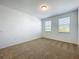 Bedroom featuring neutral carpet, base trim and two windows bringing in natural light at 12880 Westside Village Loop, Windermere, FL 34786