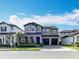 Beautiful two-story home with a manicured front lawn, stone accents, and a two-car garage at 12880 Westside Village Loop, Windermere, FL 34786
